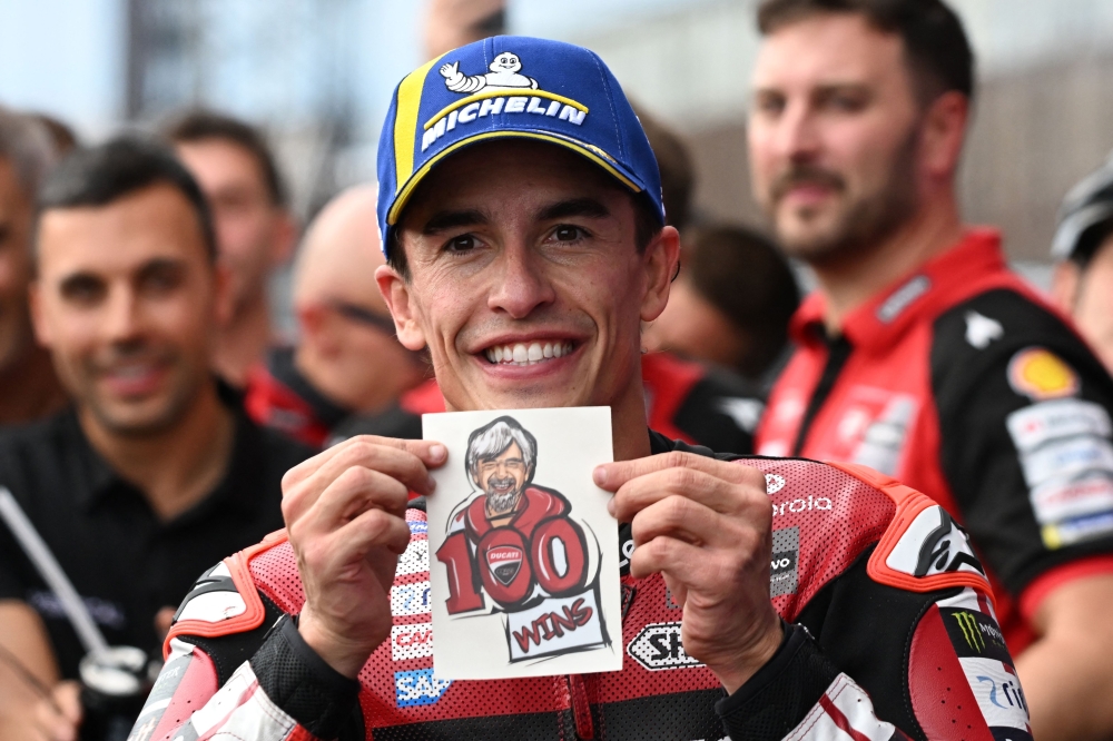 Ducati Lenovo Team rider Marc Marquez of Spain displays his Ducati team's 100th victory sticker at the Parc Ferme during the MotoGP Japanese Grand Prix on October 4, 2026. (Photo by Toshifumi Kitamura / AFP)