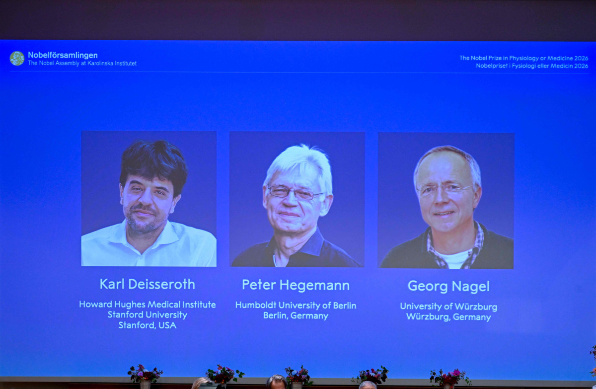 Screen displays portraits of (L-R) US scientist Karl Deisseroth and German scientists Peter Hegemann and Georg Nagel during the announcement of the winners of the 2026 Nobel Prize in Physiology or Medicine at the Karolinska Institute in Stockholm, Sweden, on October 5, 2026. Photo by Jonathan Nackstrand / AFP