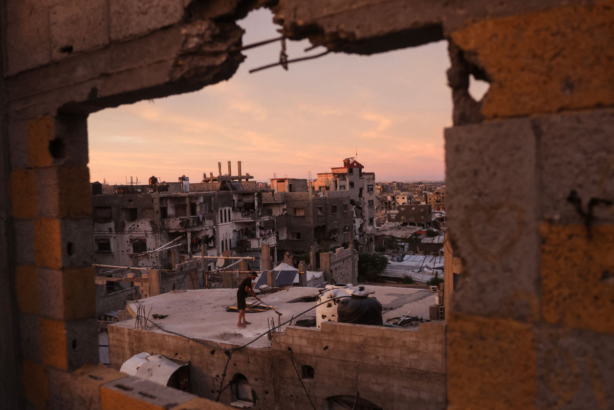 A Palestinian man cleans the roof of a building at the Jabalia refugee camp in the northern Gaza Strip on October 5, 2026. Photo by Bashar Taleb / AFP