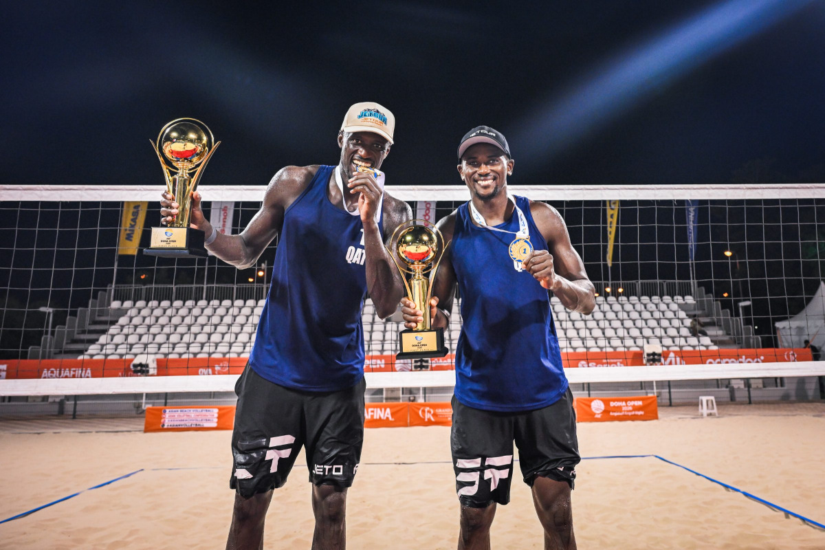 Qatar's Cherif Younousse (left) and Ahmed Tijan celebrate with their trophies.