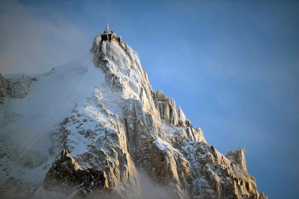 (Files) This photograph shows L'aiguille du Midi of the Massif du Mont-Blanc mountain range in the French Alps in France, on February 11, 2026. (Photo by Olivier Chassignole / AFP)