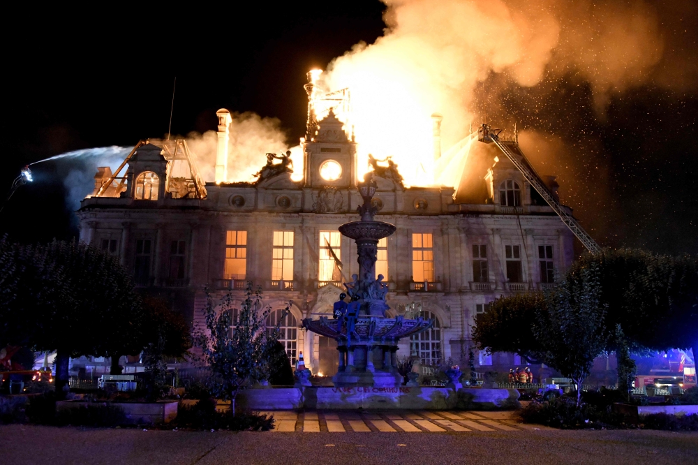This photograph shows a fire burning and destroying the city hall after a group of individuals forced entry into the building in Limoges, central France on October 17, 2026. (Photo by Pascal Lachenaud / AFP)