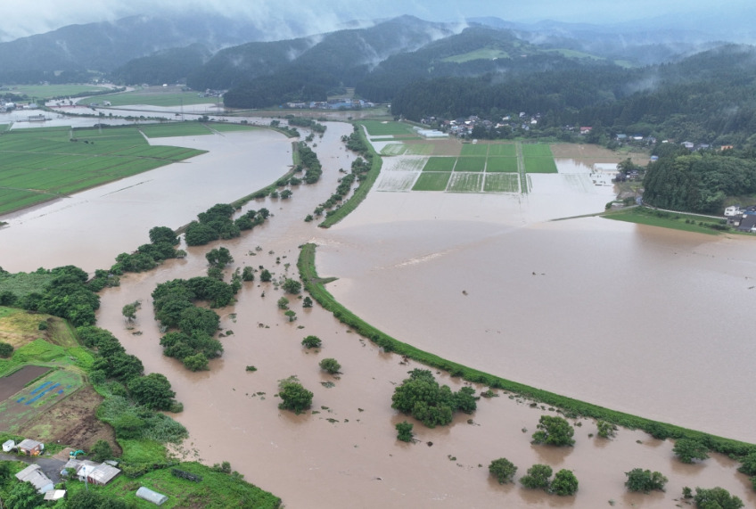 In this file photo July 25, 2024 and released courtesy of the Akita Prefecture River Sabo Division to AFP on July 26, shows flooding along the Ishizawa river, whose embankment collapsed due to heavy rains, in Yurihonjo, Akita prefecture. Photo by Handout / Akita Prefecture River Sabo Division / AFP   
