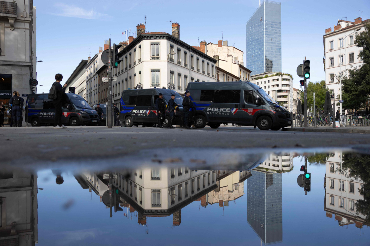 French Republican Security Corps (CRS - Compagnies Republicaines de Securite) police officers stand next to the Bourse du Travail where high school students, National Union of Students of France (UNEF) and the New Anticapitalist Party (NPA) gather for a general assembly, in Lyon on October 22, 2026. (Photo by Alex MARTIN / AFP)