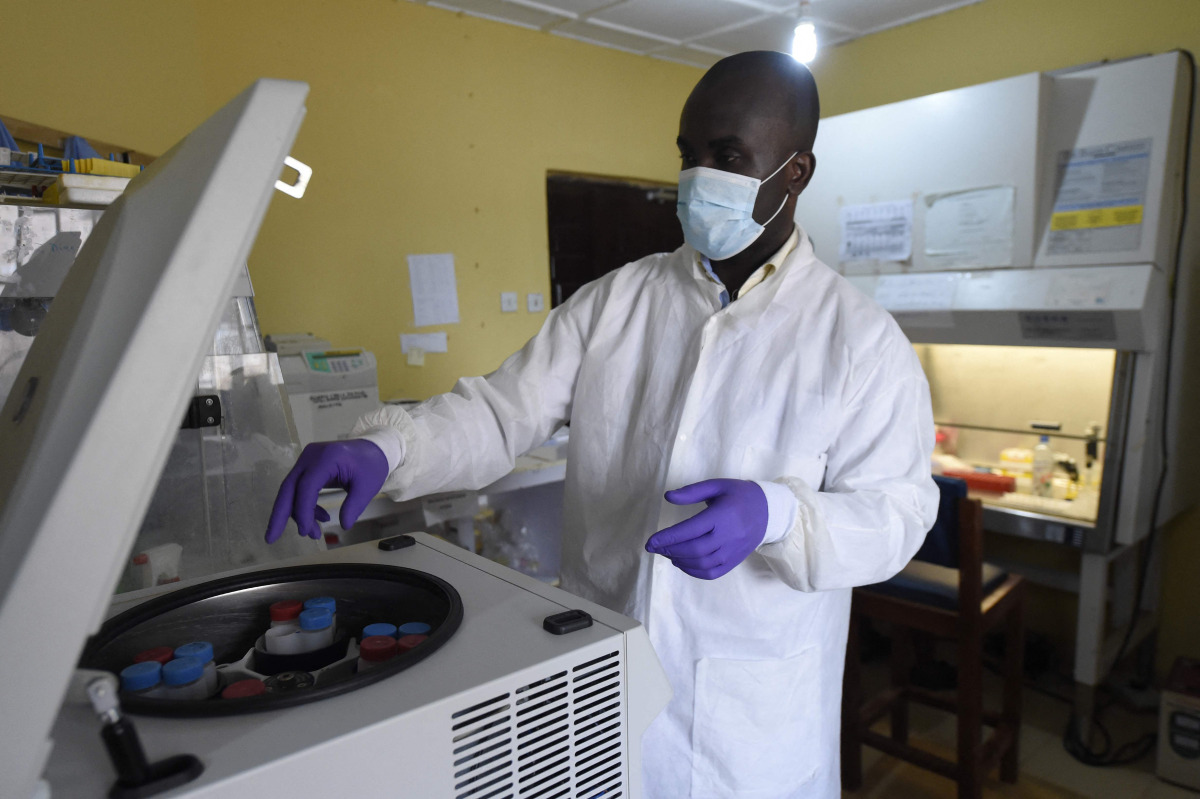 (FILES) A health official works in the laboratory extraction room of the Institute of Lassa Fever Research and Control in Irrua Specialist Teaching Hospital in Irrua, Edo State, midwest Nigeria, on March 6, 2018. (Photo by PIUS UTOMI EKPEI / AFP)