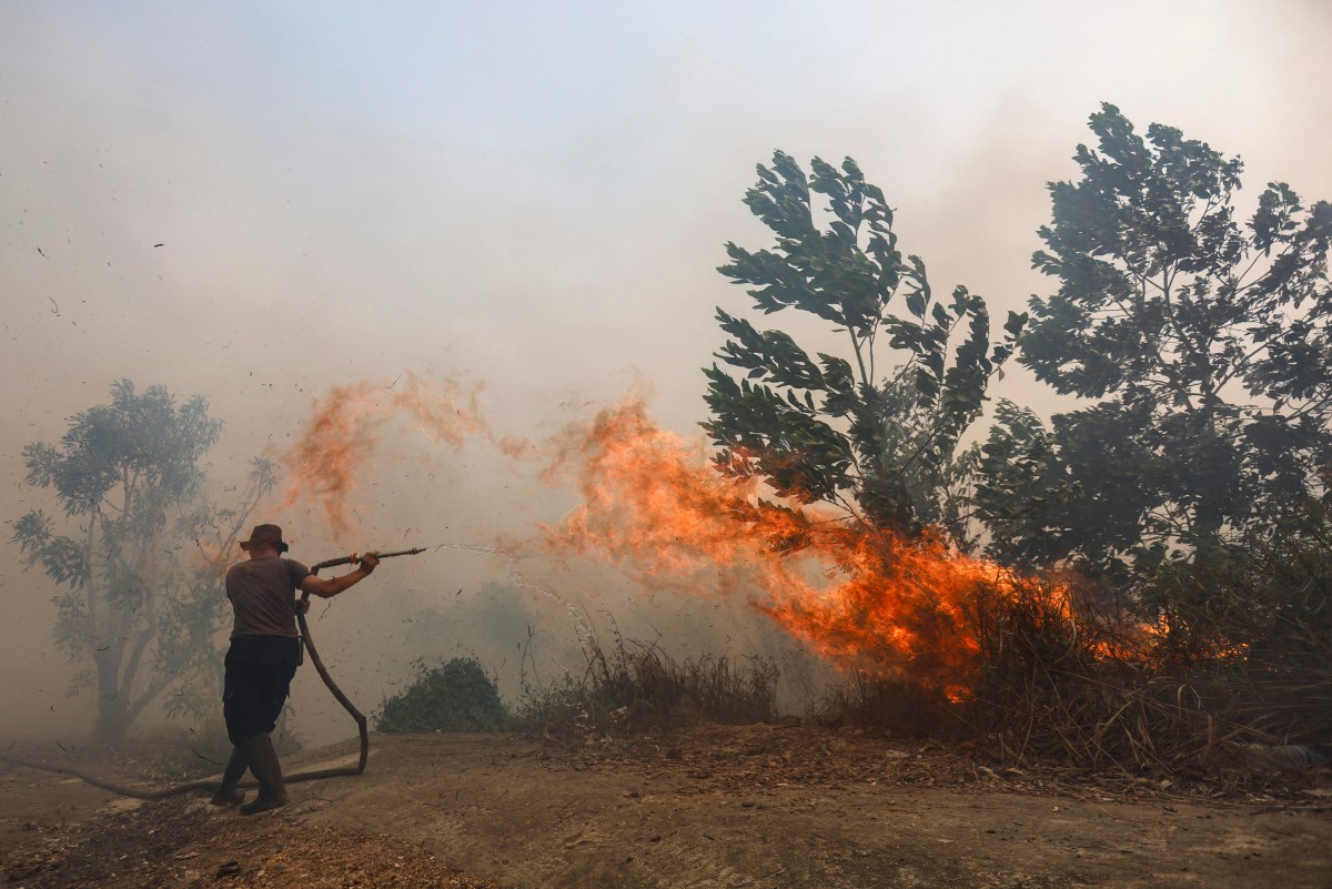 A firefighter battles a fast-moving brush fire amidst heavy smoke in Tegal Arum, Banjarbaru, South Kalimantan, on October 20, 2026. Photo by MUDA SAGALA / AFP