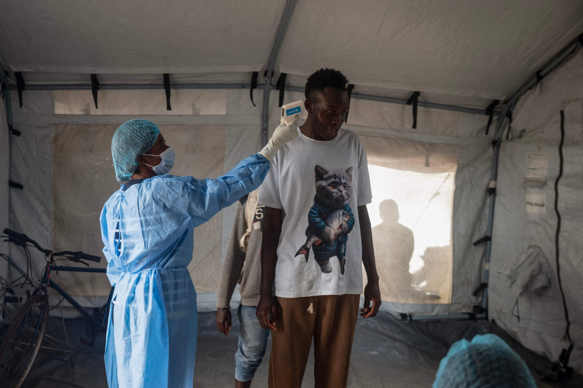 A health worker takes the temperature of a traveller after arriving in Bimbo district south-west of Bangui, on October 28, 2026. (Photo by AFP)