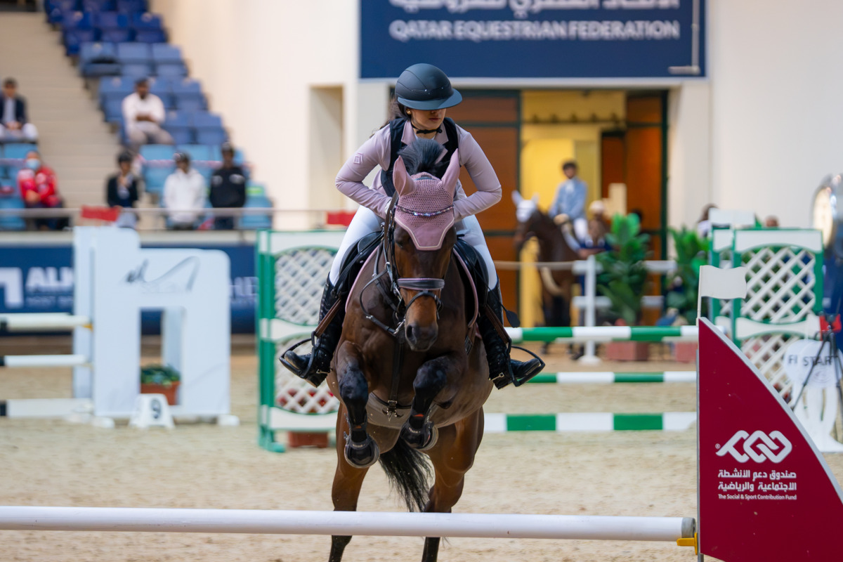 Maryam Abdulkarim Abd guides Jumbo over a fence.