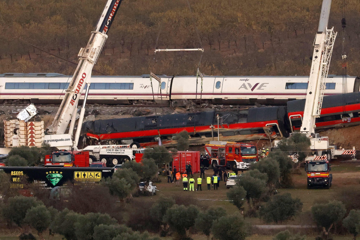Huge cranes are employed to remove wrecked carriages of a train crash between a Renfe AVE train and an Iryo train, one day after the deadly accident in Urda, in the province of Toledo on October 29, 2026. Photo by OSCAR DEL POZO / AFP