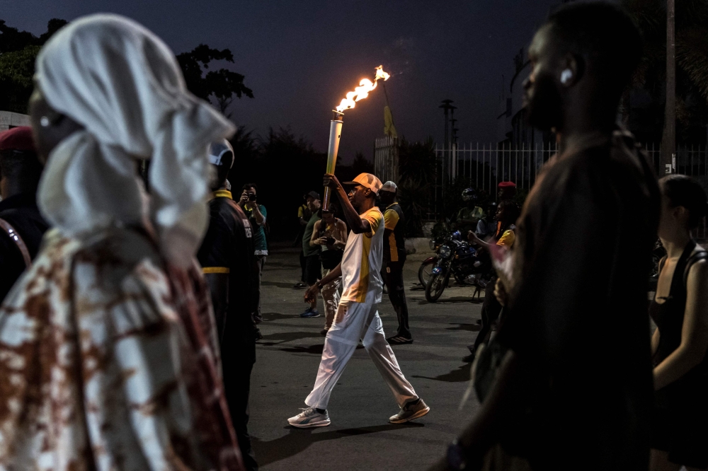 A torchbearer carries the Youth Olympic Flame on the eve of the opening ceremony of the Youth Olympic Games in Dakar on October 30, 2026. (Photo by Patrick Meinhardt / AFP)