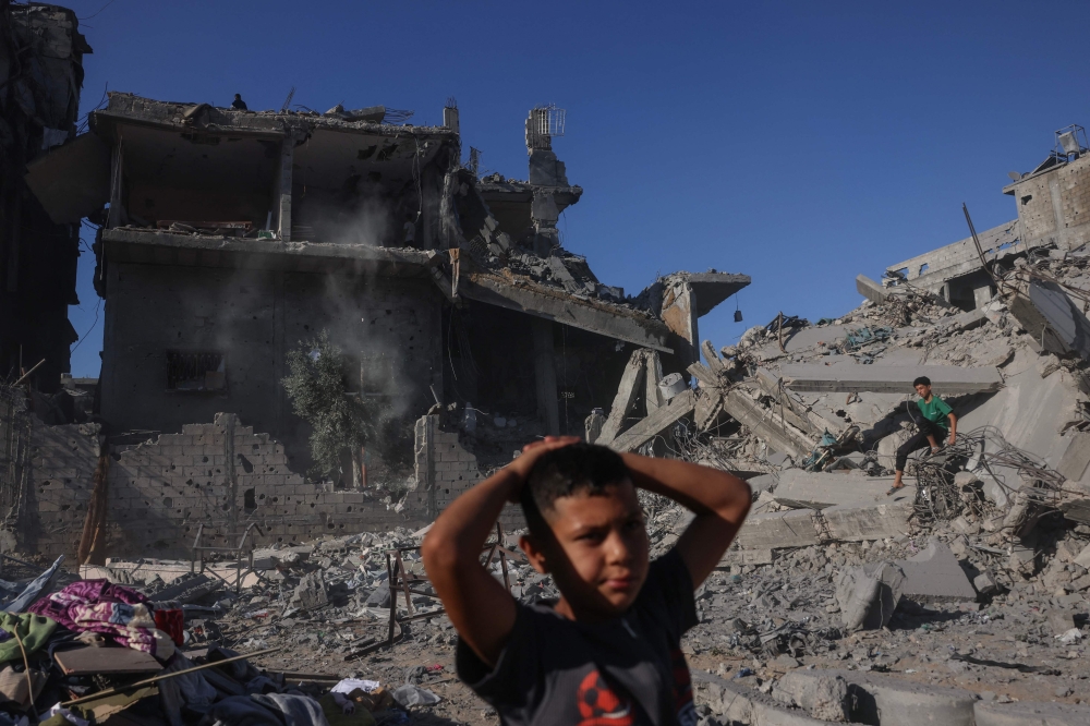 Palestinian boys stand amid the rubble after a building was hit overnight by an Israeli strike west of Jabalia in the northern Gaza Strip, on October 30, 2026. (Photo by Bashar Taleb / AFP)

